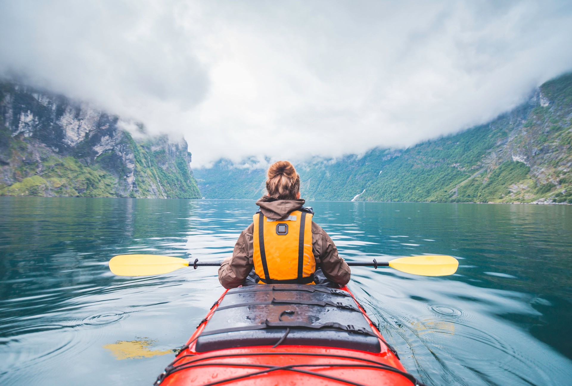 Woman kayaking in fjord in Norway.
